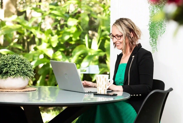 works on a laptop at an outdoor table